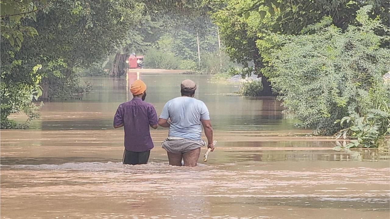 Zwei Männer waten in braunem Wasser