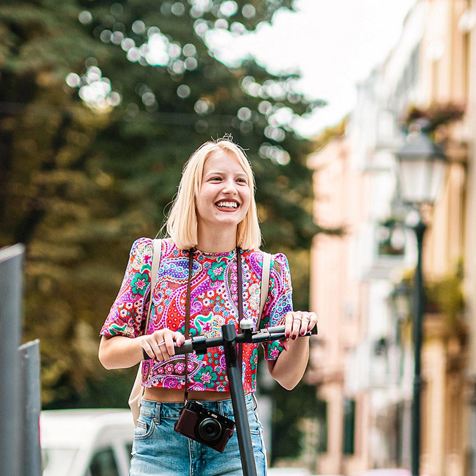 Eine Frau mit einem Roller erkundet die Stadt