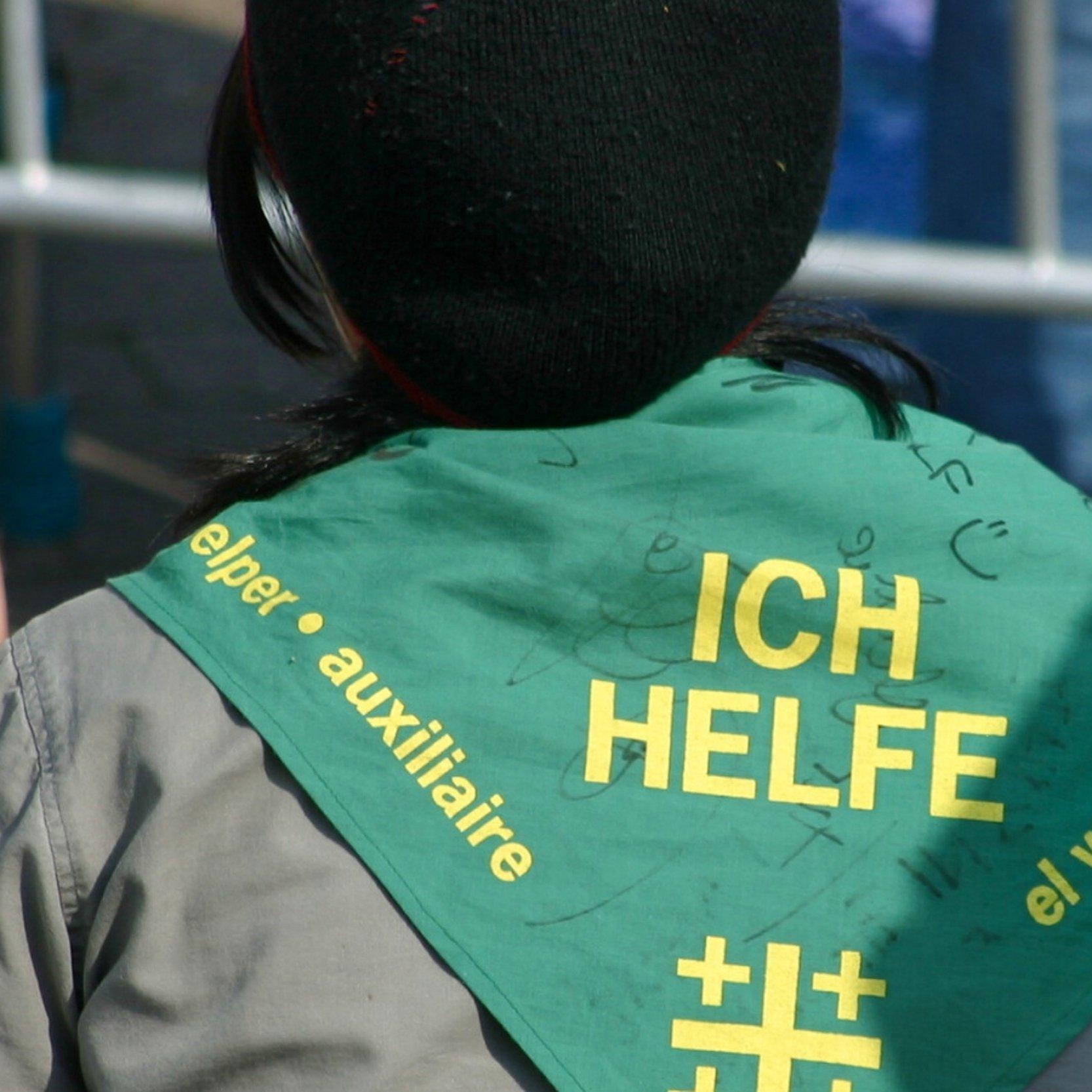 Eine Helferin trägt ein Halstuch mit der Aufschrift "Ich helde"