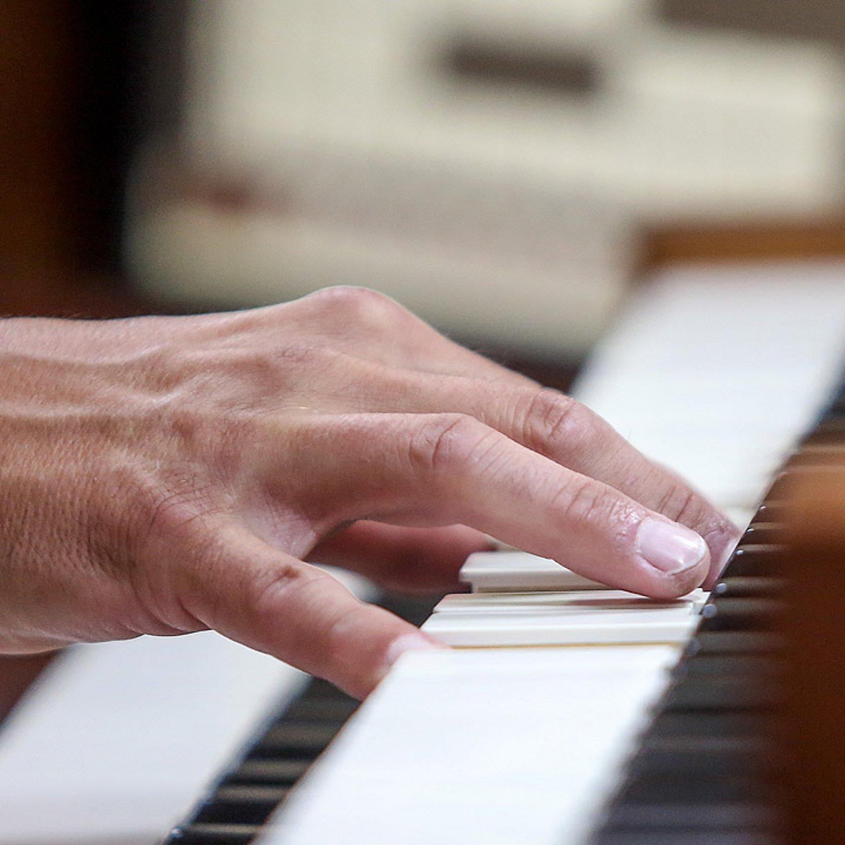 Eine Hand spielt auf einer Orgeltastatur