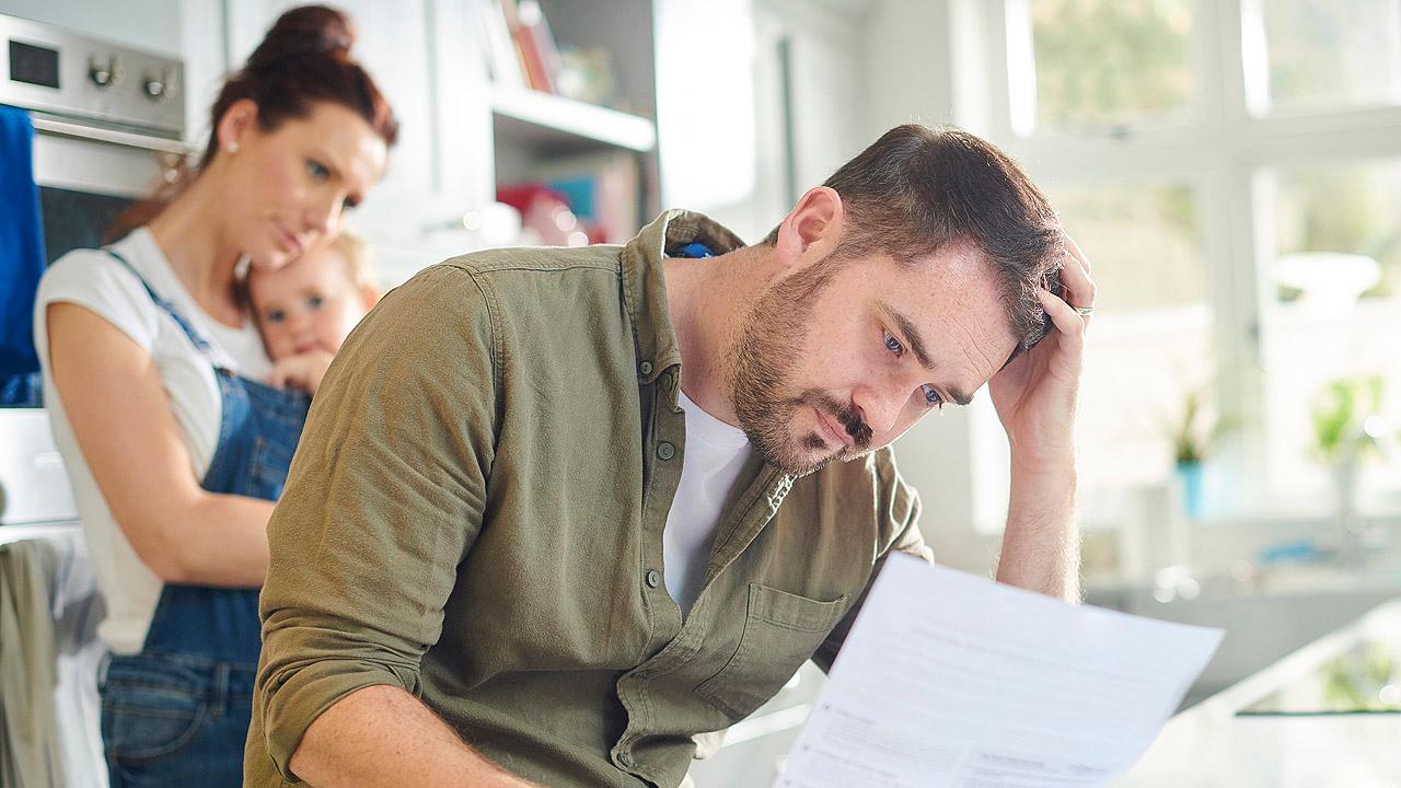 Eine Familie bekommt einen Brief, der Mann starrt entsetzt auf das Blatt