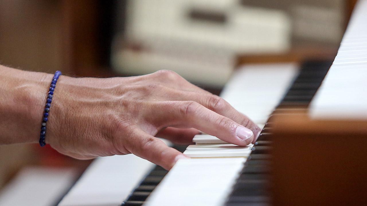 Eine Hand spielt auf einer Orgeltastatur