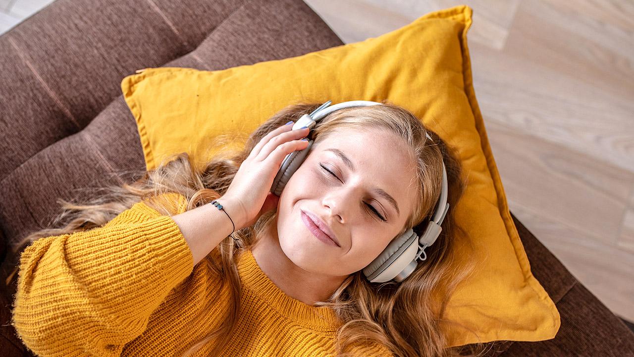 Eine junge Frau liegt auf dem Boden mit Kopfhörern