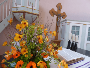 Altar mit Blumenschmuck und Kreuz