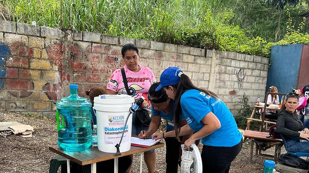Menschen mit Kanistern und anderen Materialen beschäftigen sich mit Wasseraufbereitung