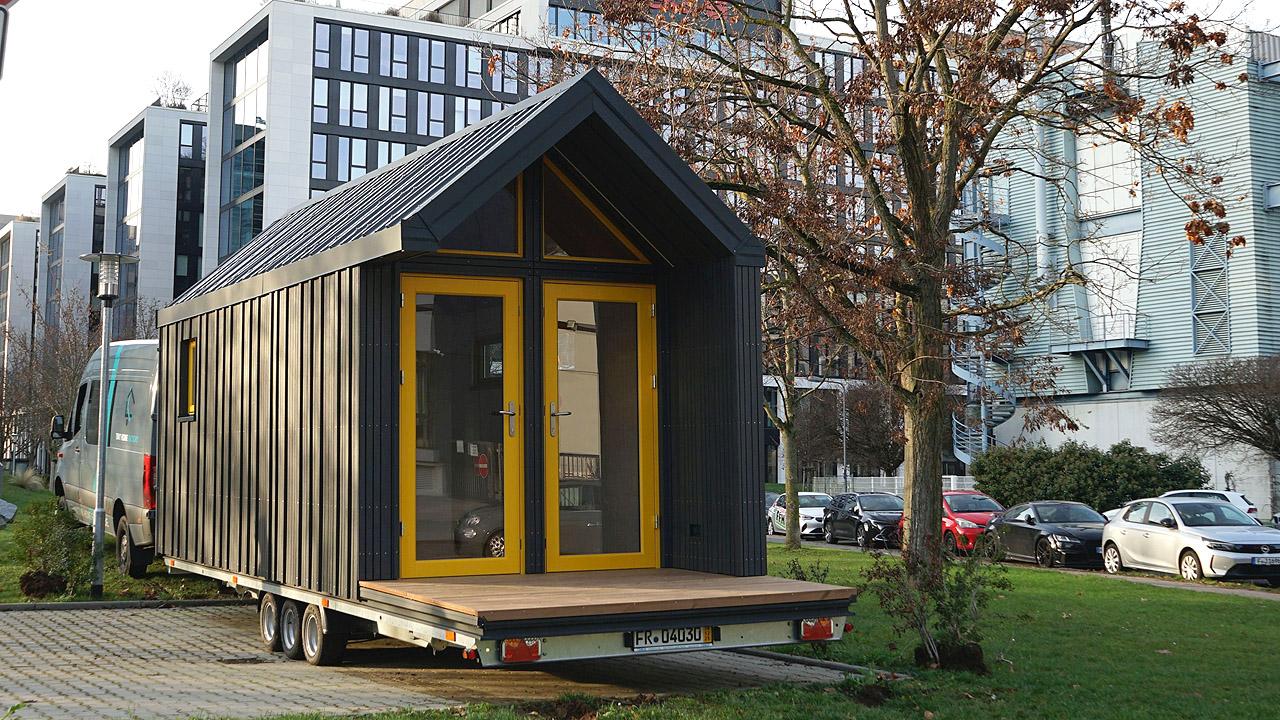 Kleine, schwarz gestrichene Kirche in Form eines Hüttchens auf einem Anhänger
