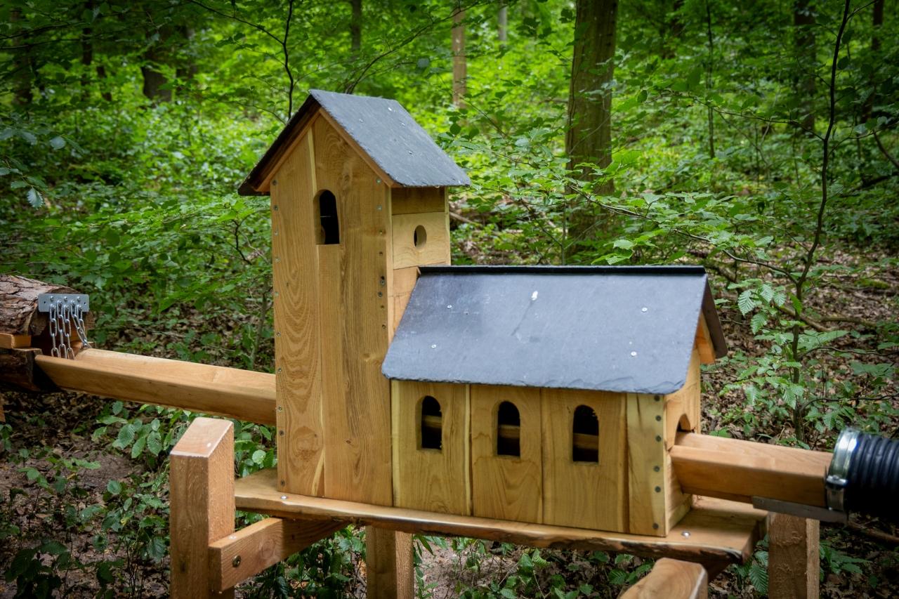 Kleine Kirche aus Holz durch die eine Kugelbahn läuft.