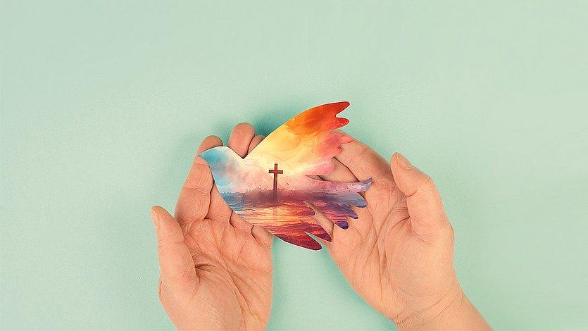 Pfingsten Papiertaube mit Kreuz in Händen