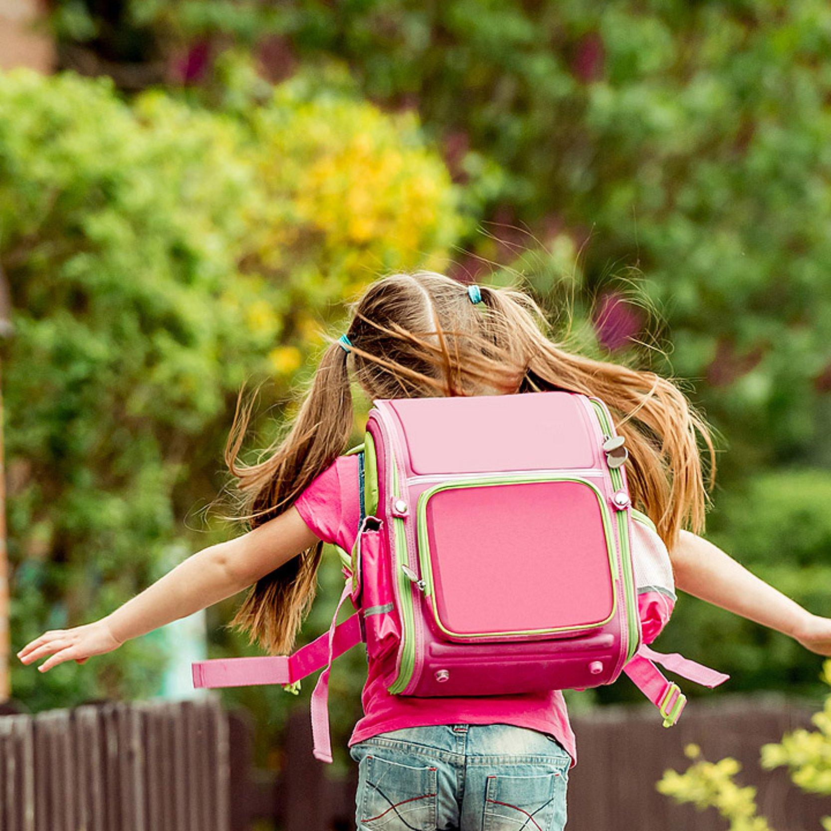 Schulweg Mädchen mit rosa Schulranzen rennt zur Schule