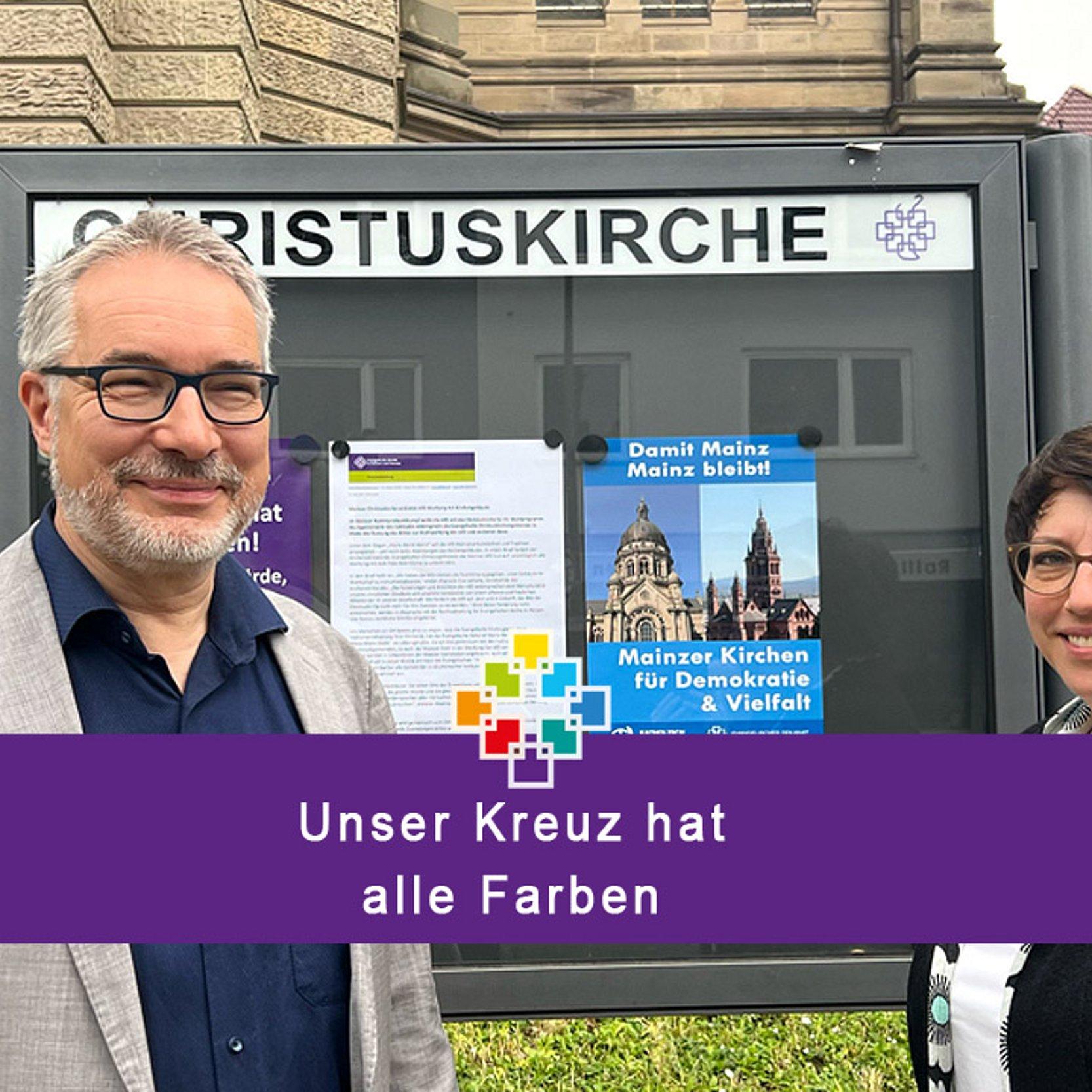 Kirchengebäude und Wahlkampf Pfarrerin Eva Lemaire und Dekan Andreas Klodt vor dem Schaukasten der Christuskirche Mainz
