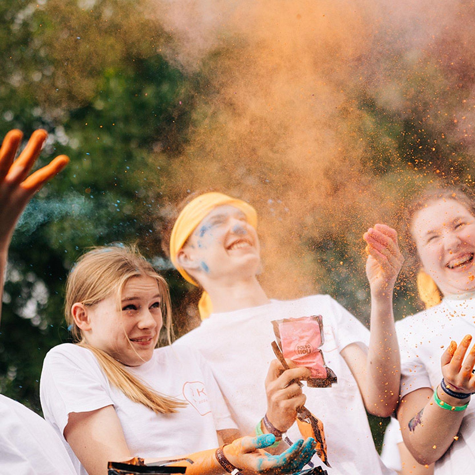 Jugendliche Jugendliche bewerfen sich mit Farbpulver und haben Spaß