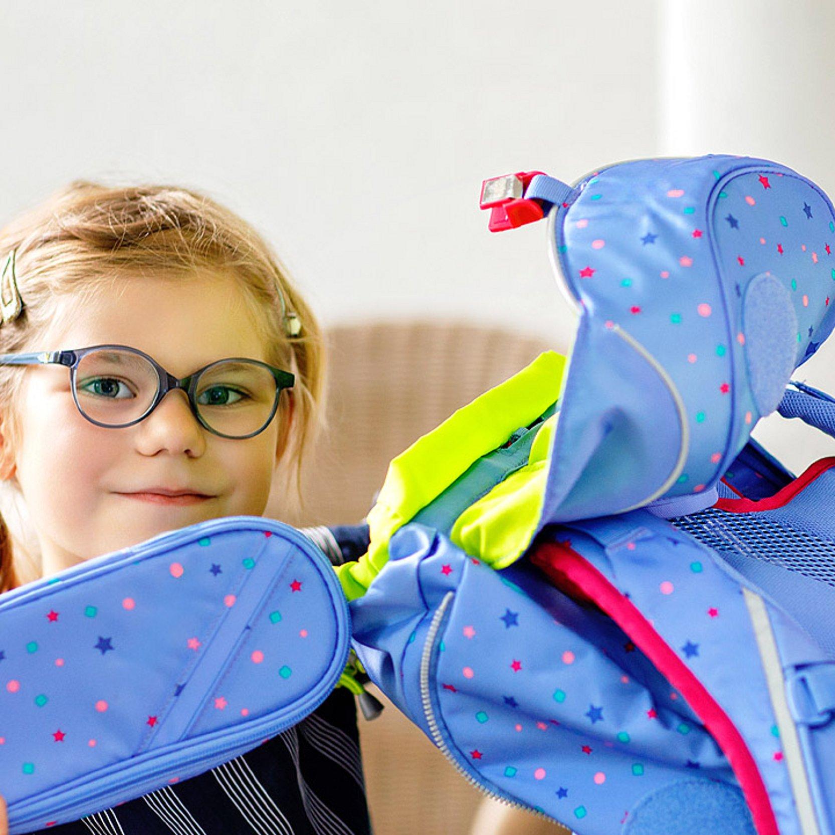 Freude über Schulranzen Ein Mädchen packt ihren Schulranzen