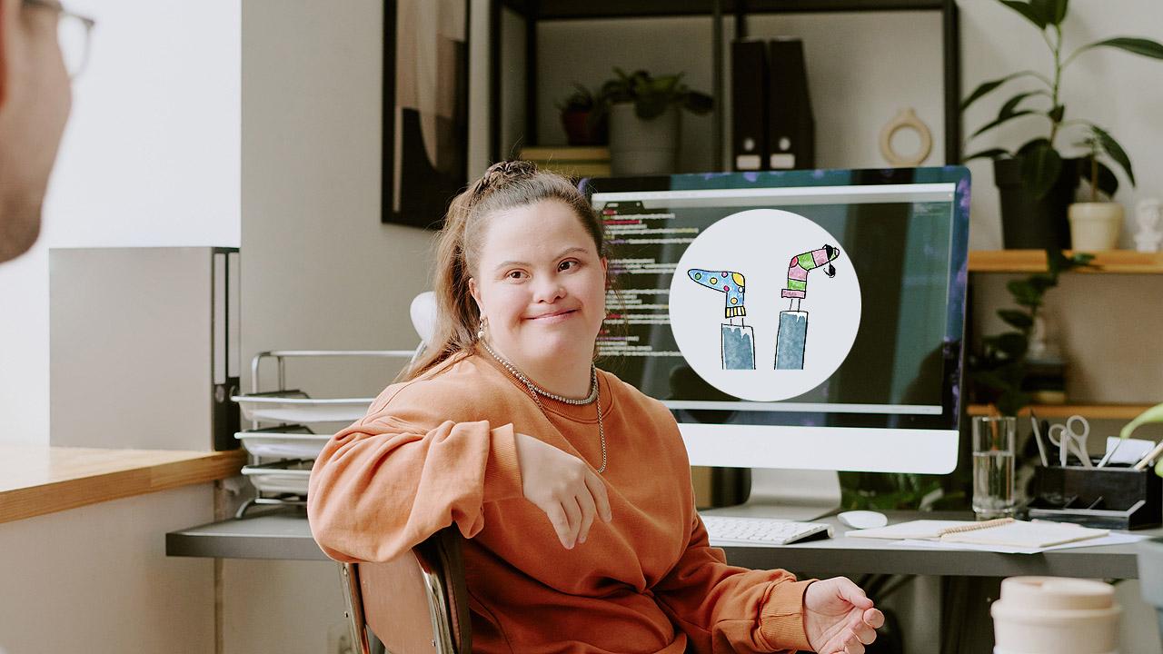 Inklusion im Job Eine junge Frau mit Trisomie 21 sitzt am Computer