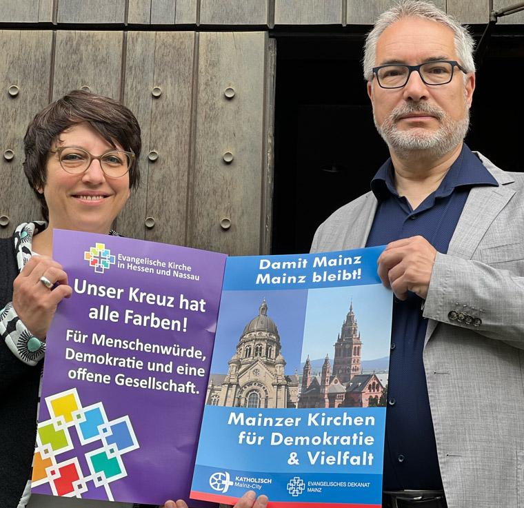 Kirchen und Wahlwerbung Pfarrerin Eva Lemaire und Dekan Andreas Klodt vor der Christuskirche Mainz halten Plakate in der Hand