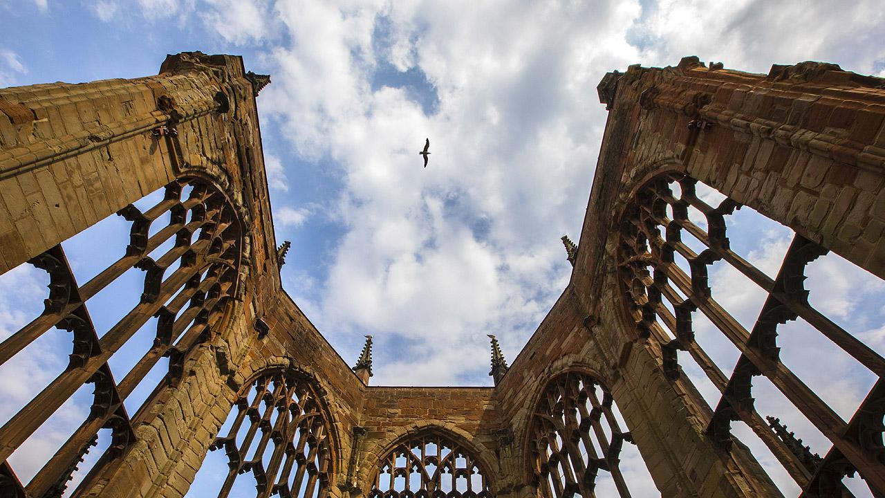 Ein Vogel fliegt den Ruinen einer Kirche