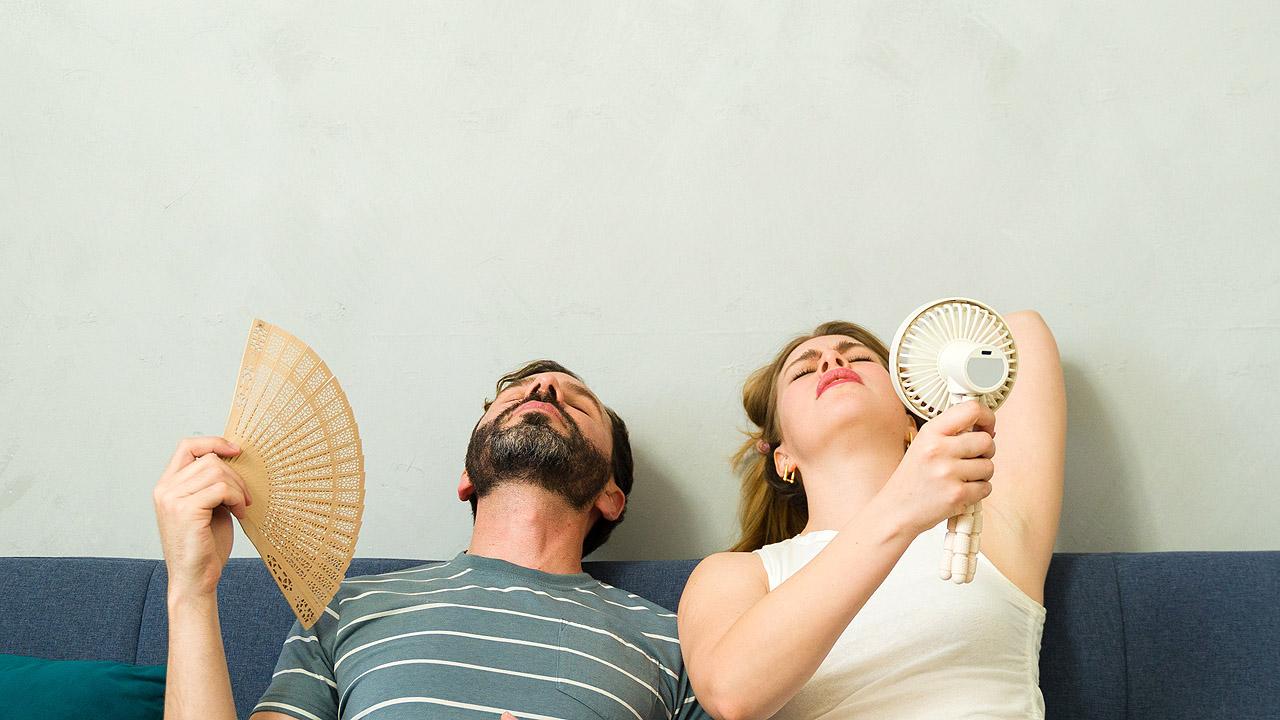 Ein erschöpftes Pärchen, dass sich Luft zufächelt