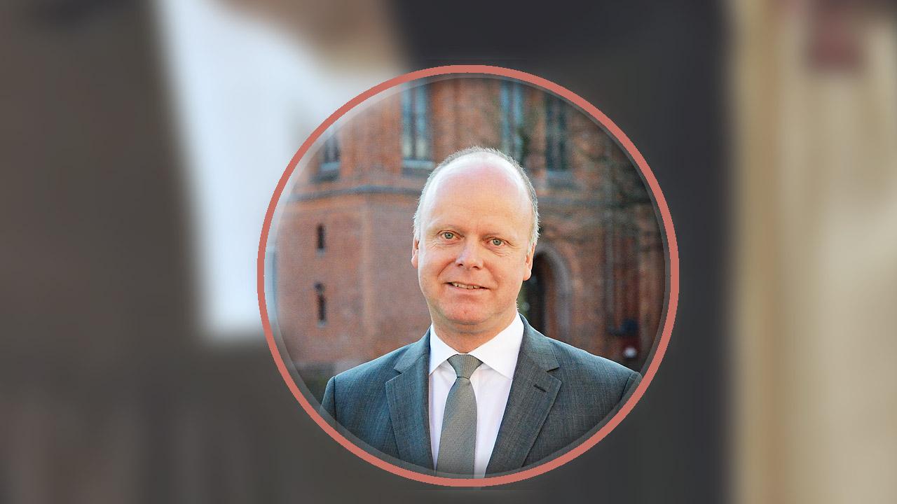 Oliver Albrecht, im Hintergrund ein Talar