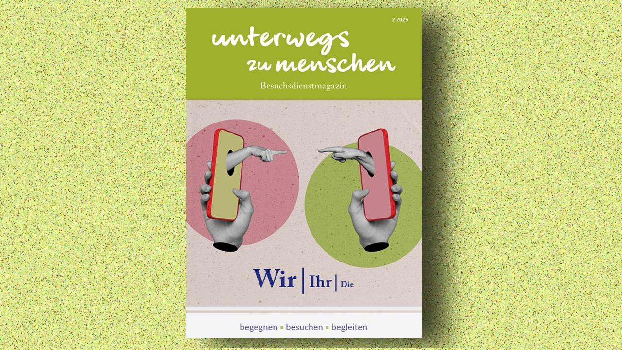 Titelseite des Besuchsdienstmagazins „unterwegs zu menschen“ (Ausgabe 2/2025). Zwei Hände halten jeweils ein Smartphone und zeigen mit dem Finger auf das jeweils andere Gerät, vor farbigen Kreisen in Rosa und Grün. Darunter der Schriftzug „Wir | Ihr | Die“. Am unteren Rand steht der Slogan „begegnen • besuchen • begleiten“.